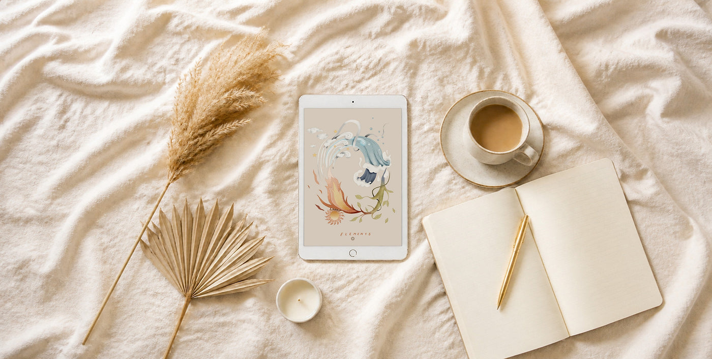 A white iPad showing an illustrated Guide from the Stars page on cream linen, with dried pampas grass and coffee